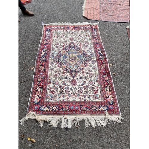 1060 - A Persian rug, having central floral cartouche, 188cm x 125cm.