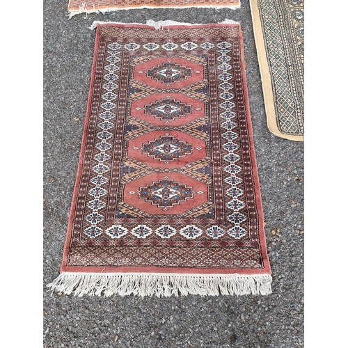 1061 - A square Persian Bokhara; together with two other Bokhara rugs.