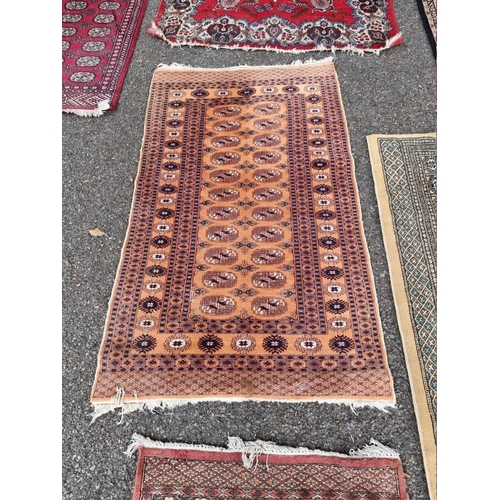 1061 - A square Persian Bokhara; together with two other Bokhara rugs.