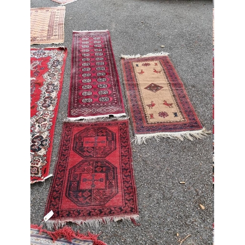 1062 - A Bokhara runner, having repeated central field; together with a small Bokhara rug and one othe... 