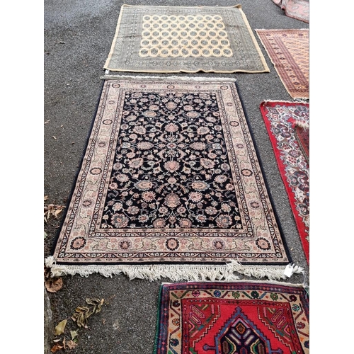 1064 - A Persian rug, having allover floral decoration, on black ground, 196cm x 140cm. ... 