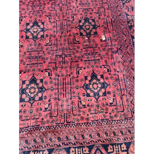 1069 - A large Bokhara rug, having repeated central field on a red ground, 286cm x 195cm, (a.f.). ... 