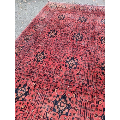 1069 - A large Bokhara rug, having repeated central field on a red ground, 286cm x 195cm, (a.f.). ... 