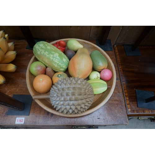 1161 - A collection of novelty painted and carved life-size fruit, together with a turned wood bowl, 38cm d... 