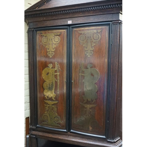 1172 - An oak standing corner cupboard, the upper part comprising a pair of 19th century rosewood and brass... 