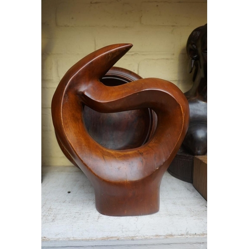 1208 - Manner of Barbara Hepworth, a carved teak sculpture, 28cm high, on associated oak stand; together wi... 