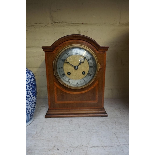 1214 - An early 20th century mahogany and satinwood banded mantel clock, the silvered chapter ring inscribe... 