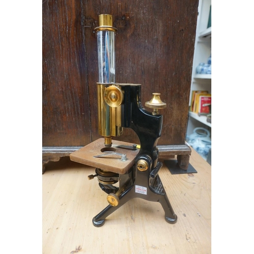 1230 - A brass and black painted monocular microscope, by Watson & Sons, lacking eye piece; together wi... 