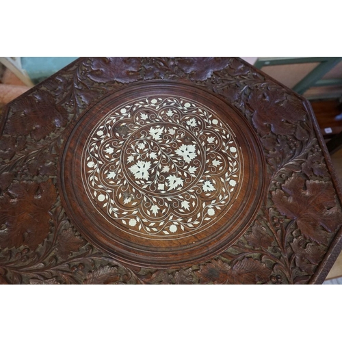 1395 - A Moorish carved hardwood and bone inlaid octagonal folding table, 58cm diameter.