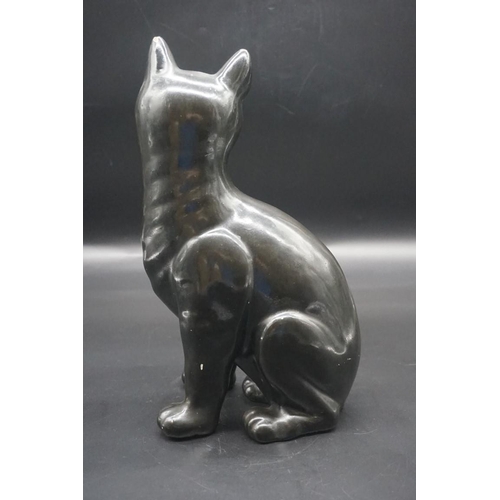 1590 - A Galle black glazed faience cat, signed, with green glass eyes, 36cm high, (s.d).