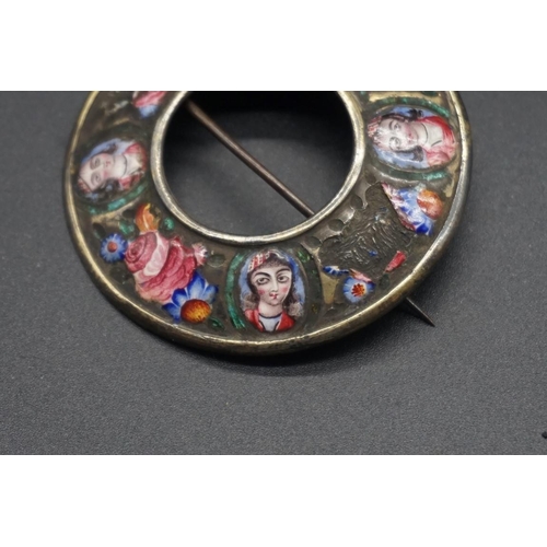 1673 - A 19th century Qajar enamel circular brooch, painted with four oval portraits separated by floral mo... 