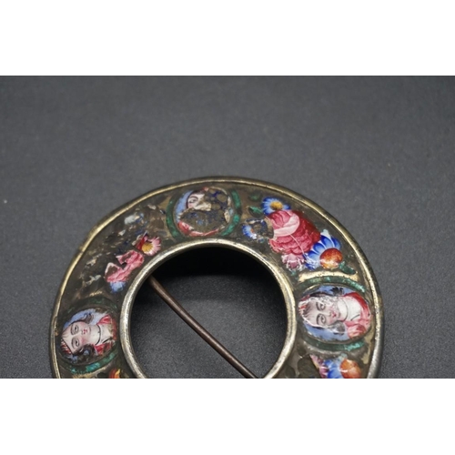 1673 - A 19th century Qajar enamel circular brooch, painted with four oval portraits separated by floral mo... 