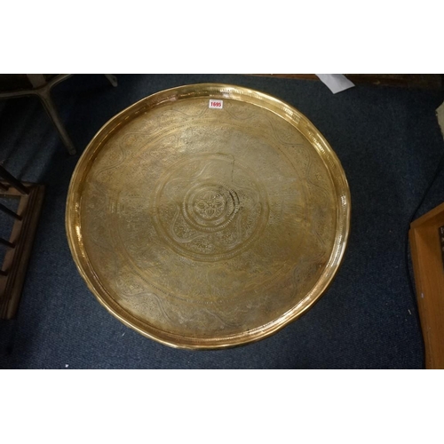 1695 - A Moroccan brass tray on folding stand, 59cm diameter. 