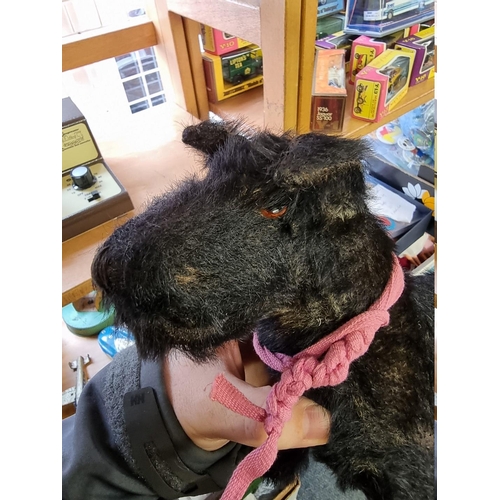 21 - A vintage black mohair Terrier, straw filled with glass eyes, 26cm long.