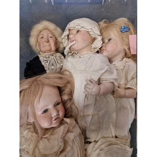 95 - Dolls: a group of nine modern dolls, six with porcelain heads, hands and lower legs, with soft bodie... 