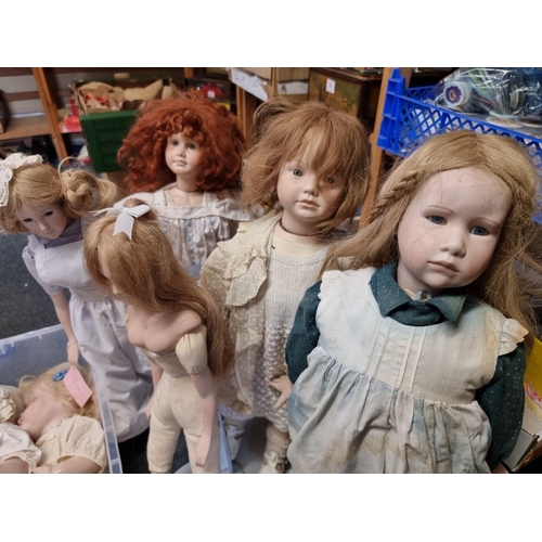 95 - Dolls: a group of nine modern dolls, six with porcelain heads, hands and lower legs, with soft bodie... 