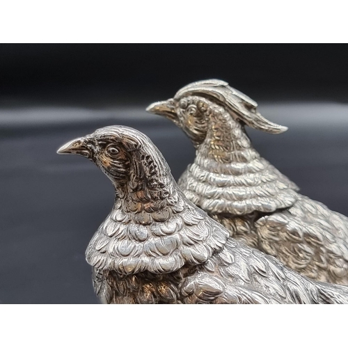 514 - A pair of continental white metal pheasants, with detachable heads, stamped '800', 1062g, largest 35... 