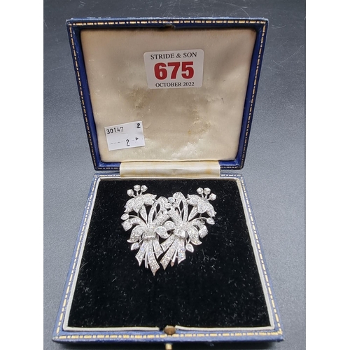 675 - An Art Deco style diamond and white metal metamorphic floral brooch, separating to form a pair of br... 