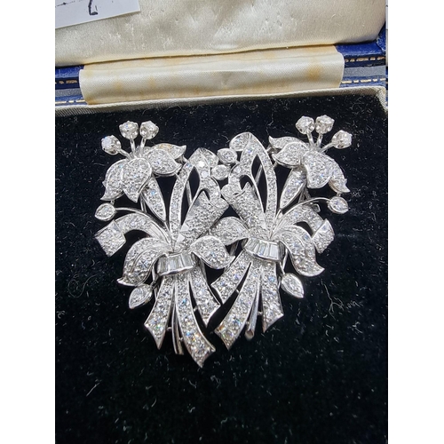 675 - An Art Deco style diamond and white metal metamorphic floral brooch, separating to form a pair of br... 