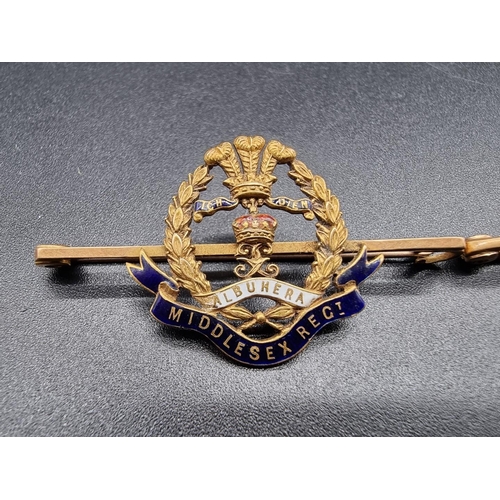 677 - A 'Middlesex Regiment' yellow metal and enamel bar brooch, stamped '15ct', 5.4g gross, 4.9cm wide; t... 