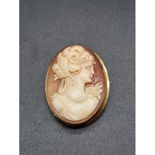 678 - A carved shell cameo brooch, in yellow metal mount stamped '750', 40mm high.