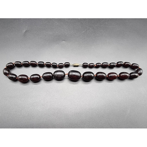 741 - A 'cherry amber' oval bead necklace, largest 30mm wide, 62cm long.