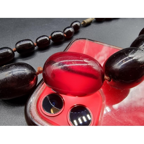 741 - A 'cherry amber' oval bead necklace, largest 30mm wide, 62cm long.