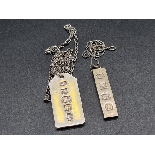 744 - A silver 1oz ingot pendant, together with another 0.5oz example.