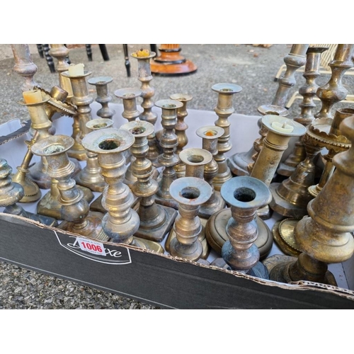 1006 - A quantity of antique brass candlesticks. 