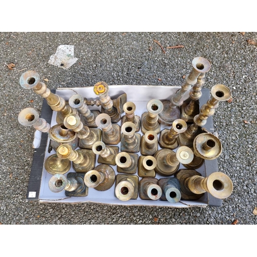 1006 - A quantity of antique brass candlesticks. 