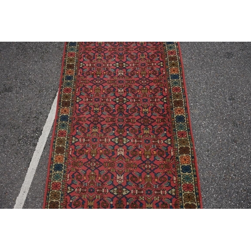 1065 - A Persian runner, having repeated decoration to central field, with floral borders, 359 x 95cm.... 