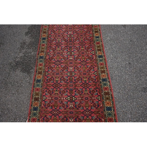 1065 - A Persian runner, having repeated decoration to central field, with floral borders, 359 x 95cm.... 