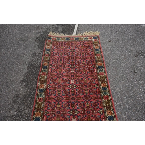 1065 - A Persian runner, having repeated decoration to central field, with floral borders, 359 x 95cm.... 