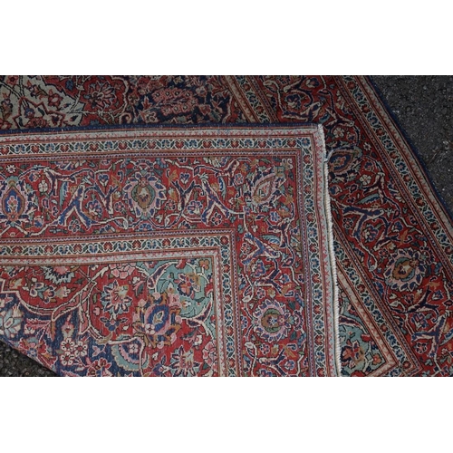 1074 - A pair of Persian rugs, having central floral medallions, with floral borders, with floral borders o... 