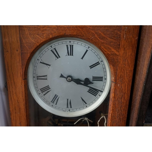 1379 - An oak electric master wall clock, 126cm high, with pendulum.