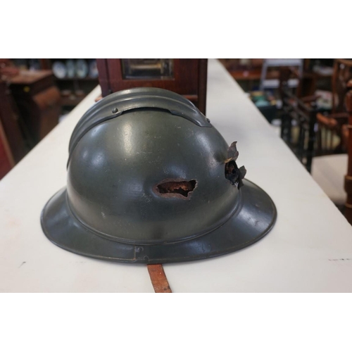 1808 - An interesting Italian World War I Adrian steel helmet, with liner and strap, combat bullet entry an... 