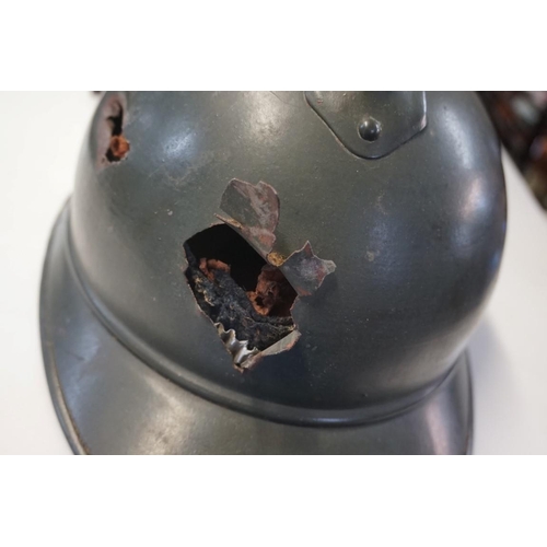 1808 - An interesting Italian World War I Adrian steel helmet, with liner and strap, combat bullet entry an... 