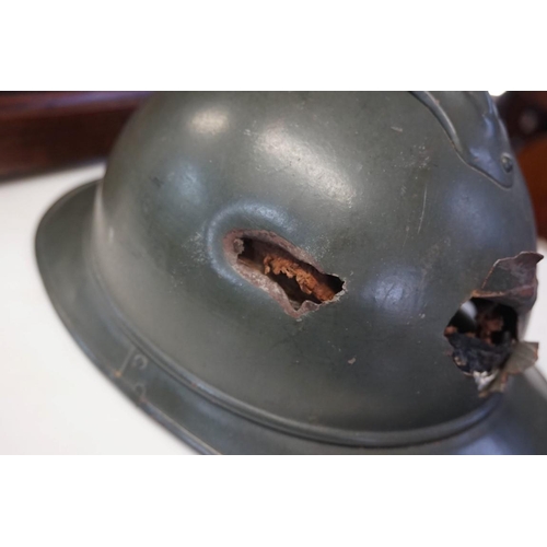 1808 - An interesting Italian World War I Adrian steel helmet, with liner and strap, combat bullet entry an... 