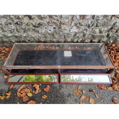 1022 - A glass table top display cabinet, 134cm wide x 45cm deep.