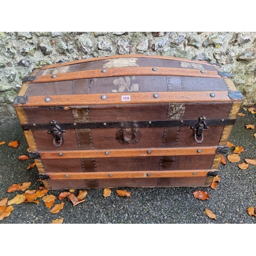 1038 - A vintage wood bound dome topped trunk. 