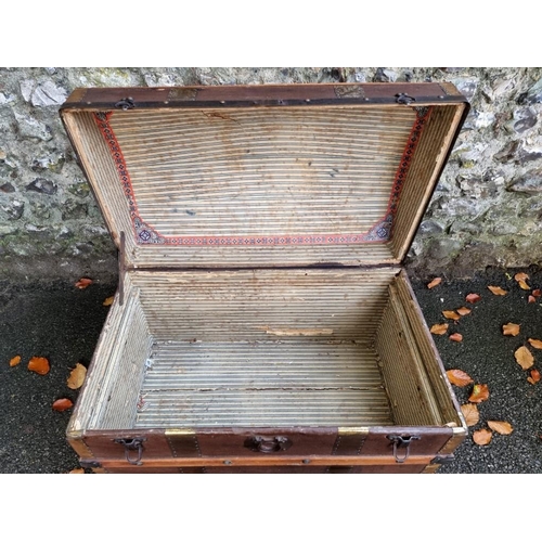 1038 - A vintage wood bound dome topped trunk. 