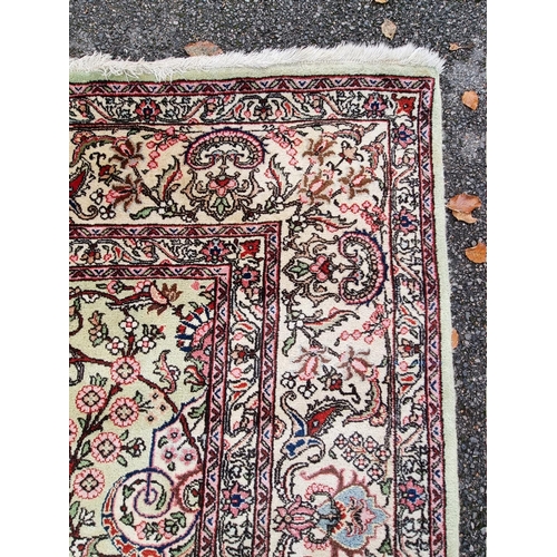 1079 - A large Persian carpet, having large central medallion, with floral central field on a green ground,... 