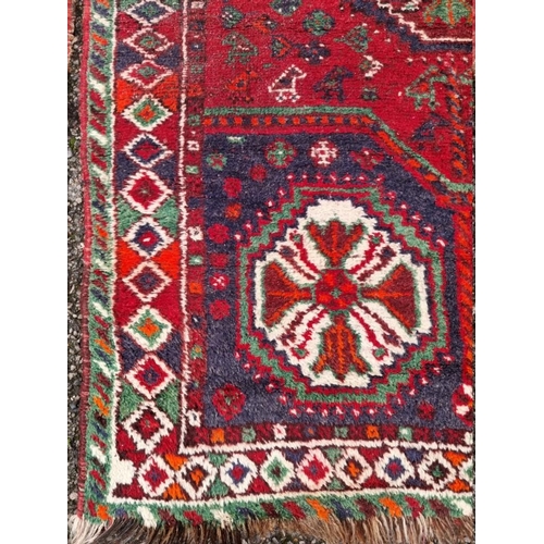 1097 - A Persian rug, having four central medallions, on a red ground, 201 x 94cm; together with another ru... 