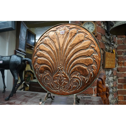 1107 - An embossed copper fire screen, 52cm diameter.