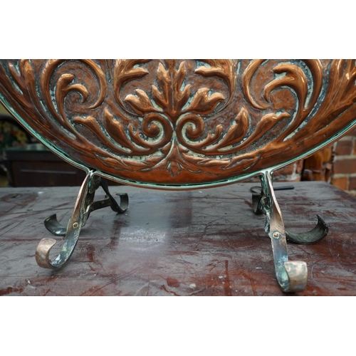 1107 - An embossed copper fire screen, 52cm diameter.