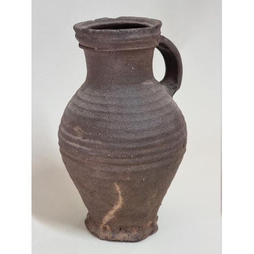 1277 - A mediaeval pottery jug, probably 14th century, with ribbed decoration, 24.5cm high.... 