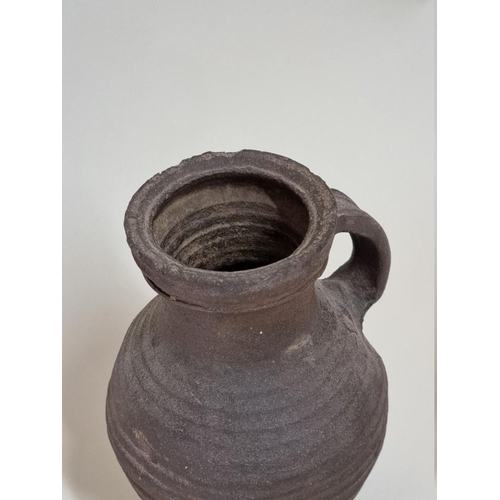 1277 - A mediaeval pottery jug, probably 14th century, with ribbed decoration, 24.5cm high.... 