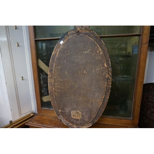 1306 - An Irish style ebonized and parcel gilt oval wall mirror, 74.5 x 46.5cm. 