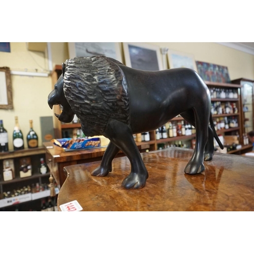 1428 - A carved ebony lion, 38cm long. 