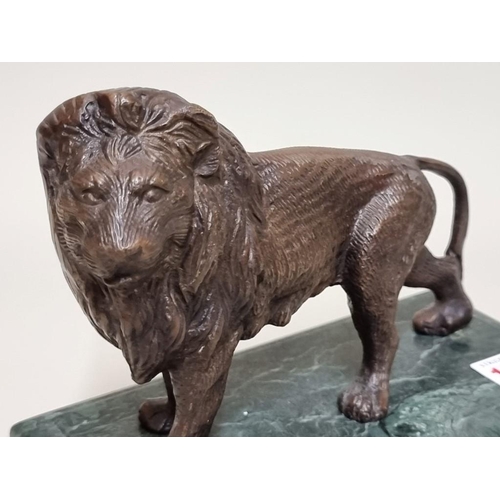 1532 - A bronze lion, on green marble base, 21cm wide.